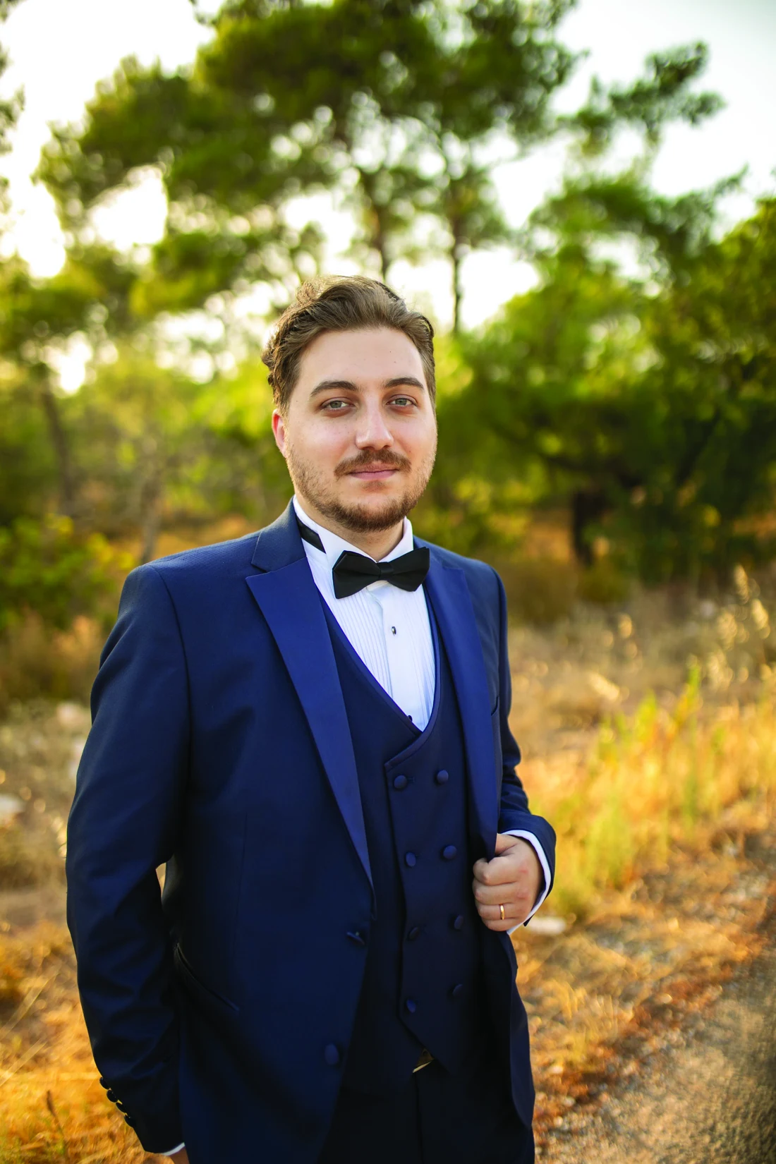 Furkan Çapar outdoors in a navy suit